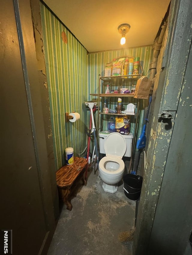 bathroom featuring concrete floors and toilet