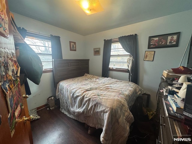 bedroom with multiple windows and wood finished floors