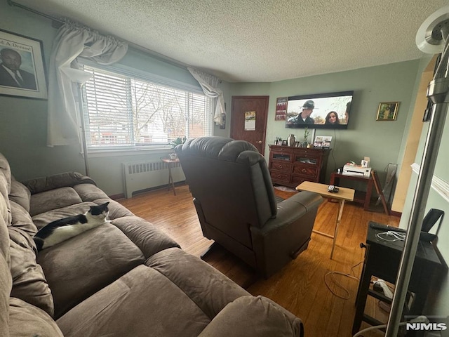 living room featuring radiator, a textured ceiling, and wood finished floors