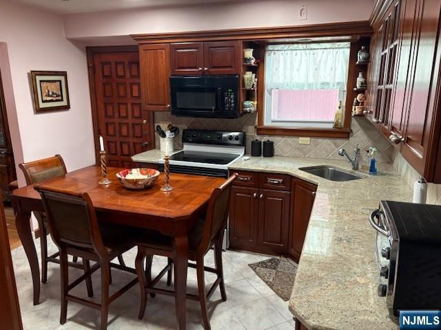 kitchen featuring range with electric stovetop, open shelves, tasteful backsplash, a sink, and black microwave