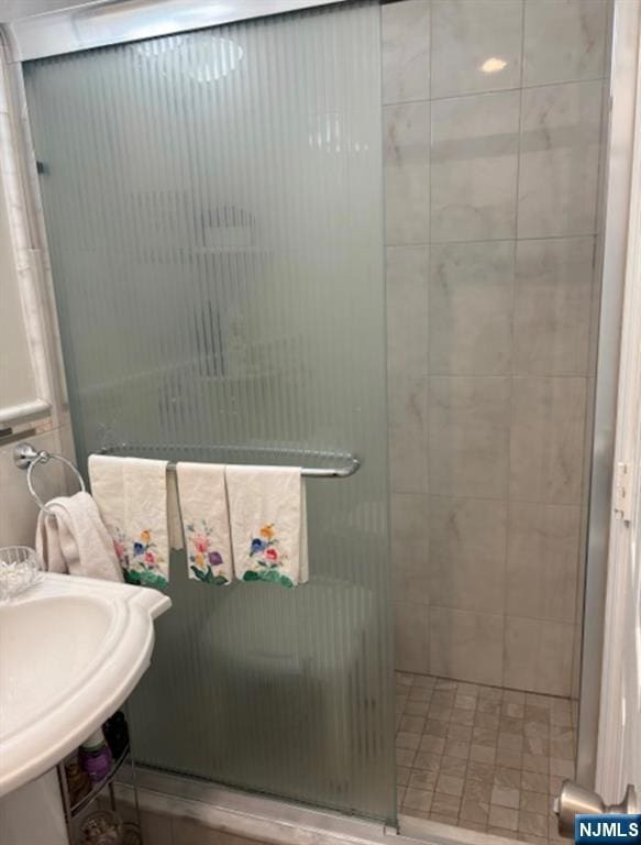 full bath featuring a shower stall and a sink