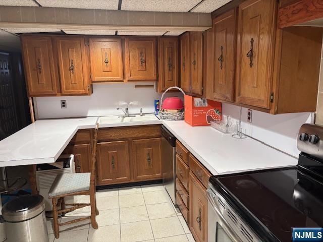 kitchen featuring light countertops, appliances with stainless steel finishes, and brown cabinetry