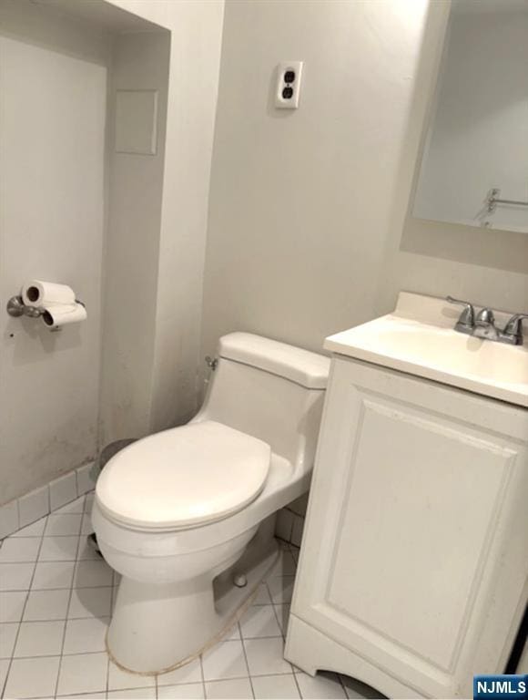 bathroom with toilet, tile patterned flooring, and vanity