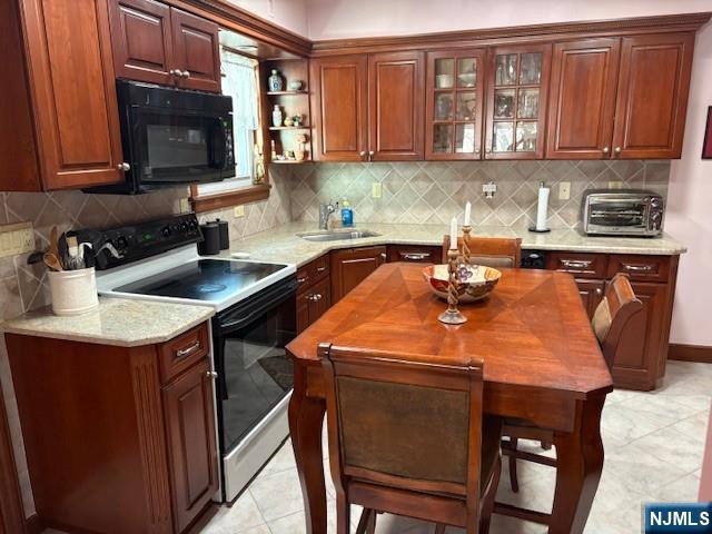 kitchen with a toaster, decorative backsplash, electric range oven, black microwave, and a sink