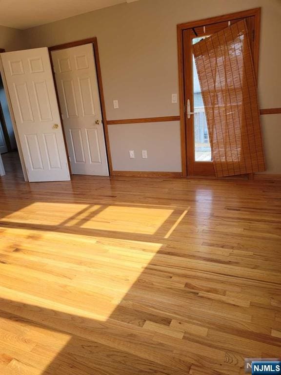 empty room featuring wood finished floors and baseboards