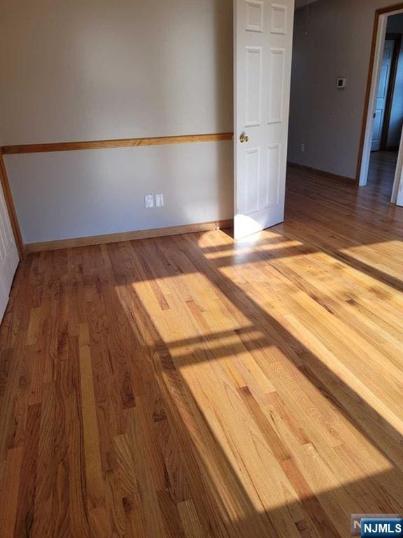 unfurnished room featuring baseboards and wood finished floors