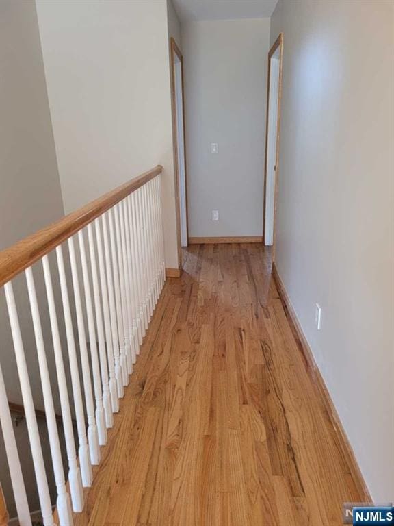 hall with light wood-type flooring and baseboards