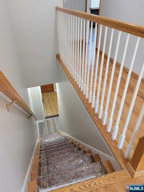 staircase featuring baseboards and wood finished floors