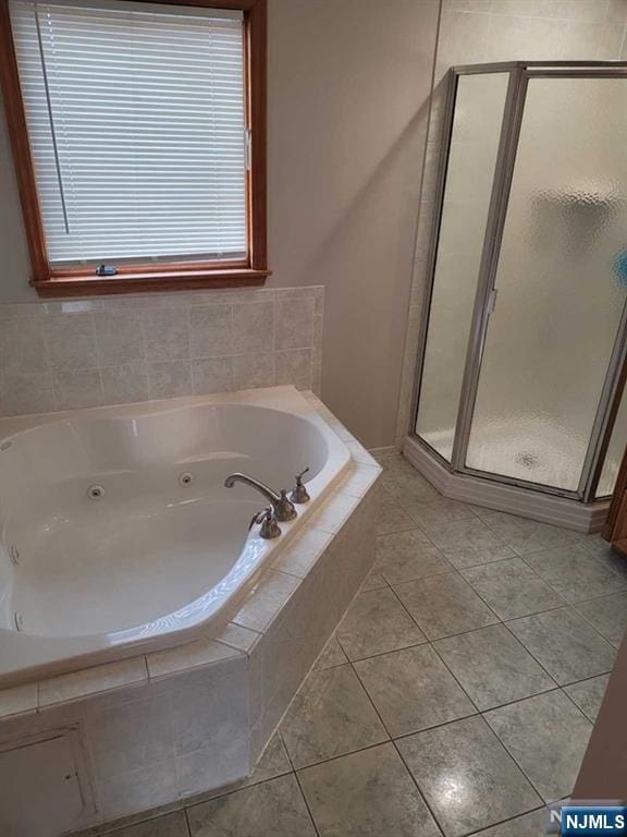 full bath featuring a whirlpool tub, a shower stall, and tile patterned floors