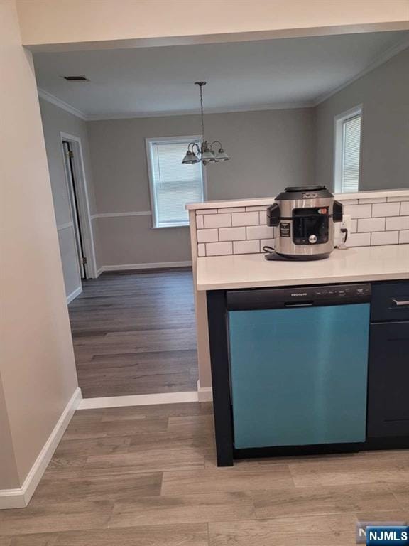 kitchen with light wood finished floors, baseboards, dishwasher, ornamental molding, and light countertops