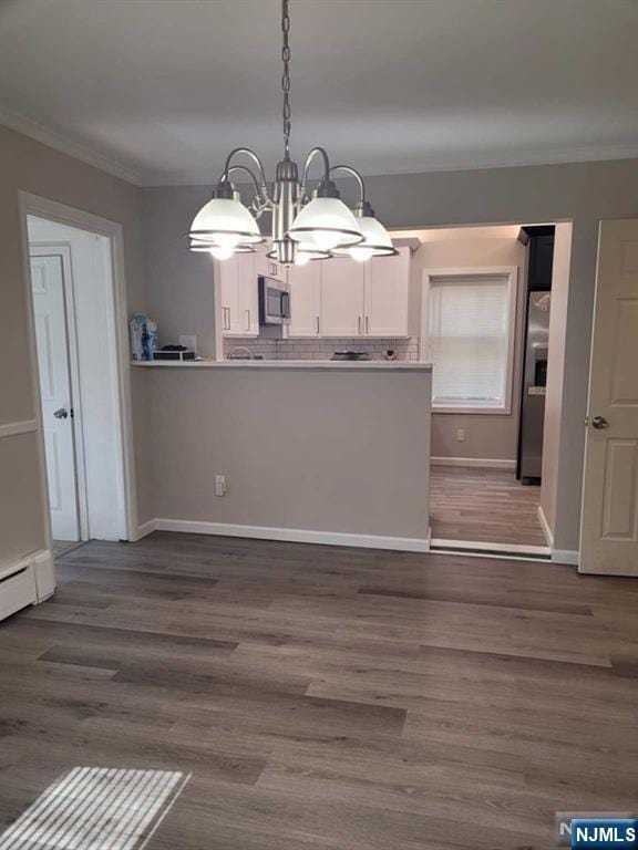 kitchen featuring stainless steel appliances, ornamental molding, and dark wood finished floors