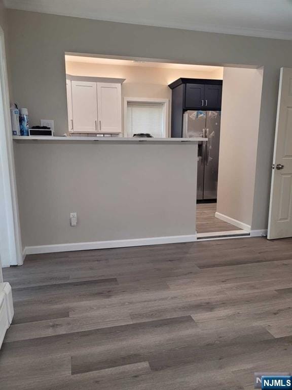 kitchen featuring crown molding, wood finished floors, freestanding refrigerator, and baseboards