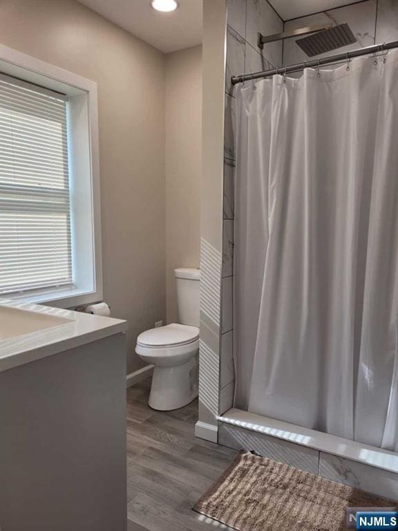 full bathroom featuring visible vents, a shower with shower curtain, toilet, vanity, and wood finished floors