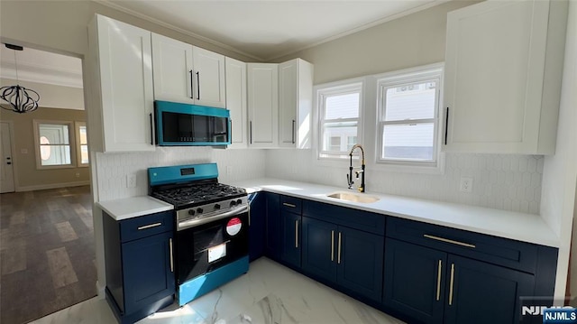 kitchen featuring stainless steel gas stove, decorative backsplash, a sink, and blue cabinets