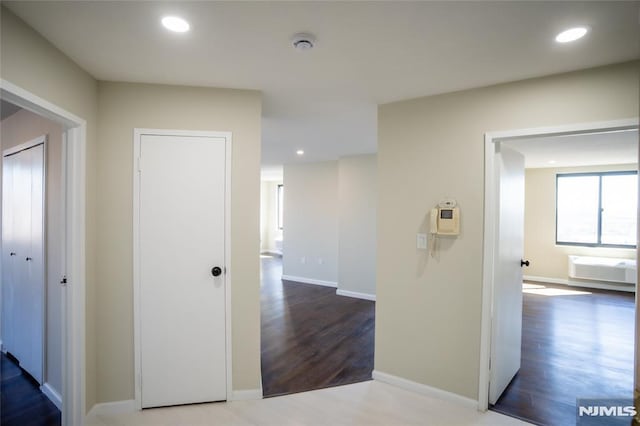 corridor featuring recessed lighting, wood finished floors, and baseboards