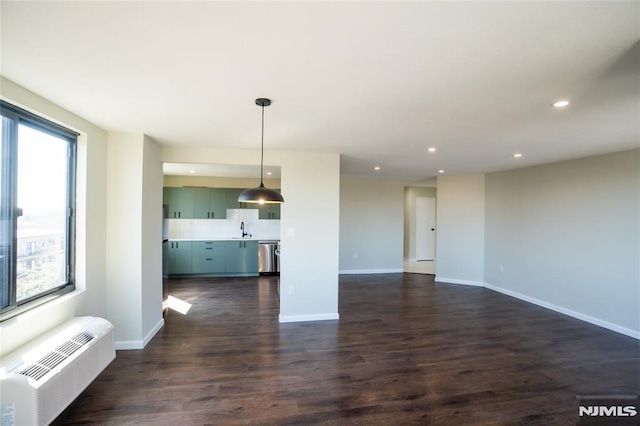 interior space with an AC wall unit, a sink, dark wood-style floors, recessed lighting, and baseboards