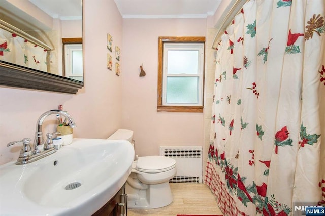 full bathroom featuring toilet, a shower with shower curtain, ornamental molding, radiator heating unit, and a sink