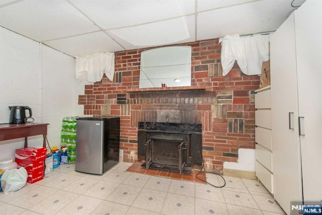 living room featuring a drop ceiling and a fireplace