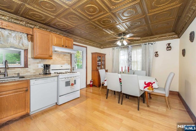 kitchen with an ornate ceiling, tasteful backsplash, a sink, white appliances, and under cabinet range hood