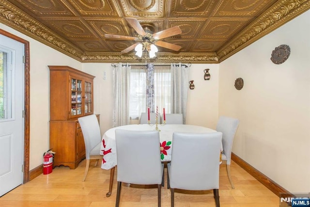 dining space featuring an ornate ceiling, light wood finished floors, baseboards, and a ceiling fan