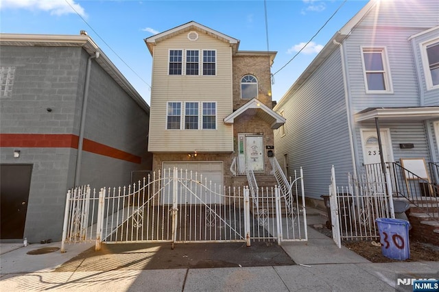 view of front of home featuring brick siding, a fenced front yard, an attached garage, and a gate