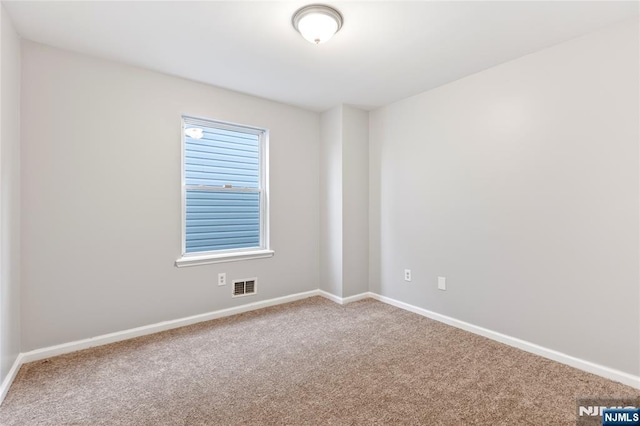 carpeted empty room featuring baseboards and visible vents