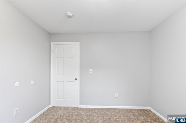 unfurnished room featuring carpet and baseboards