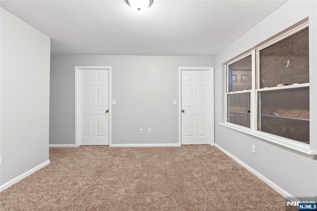 spare room with carpet and baseboards