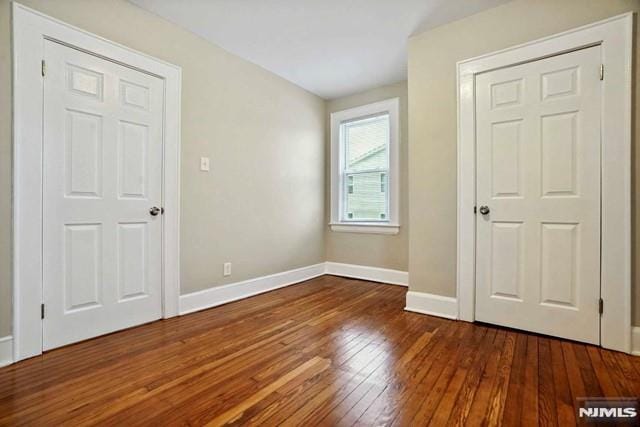 unfurnished bedroom featuring hardwood / wood-style floors and baseboards