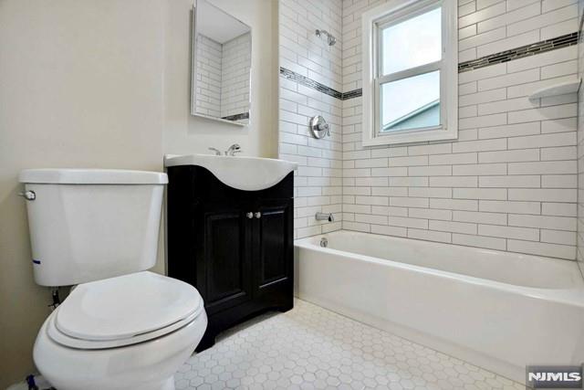 bathroom with shower / washtub combination, toilet, and vanity