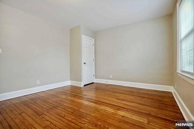 spare room featuring wood finished floors and baseboards