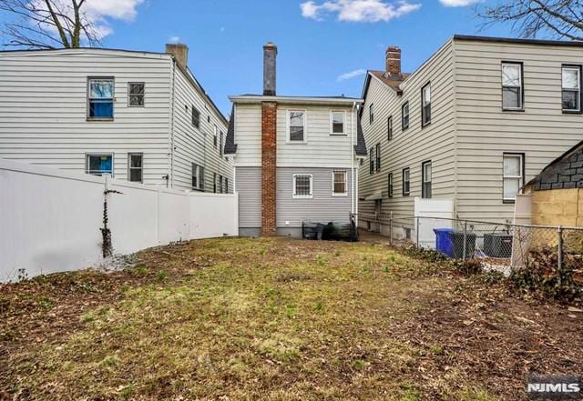 rear view of property featuring fence