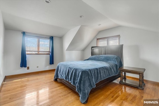 bedroom with light wood-type flooring, lofted ceiling, and baseboards