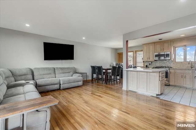 living area with recessed lighting, a healthy amount of sunlight, and light wood finished floors