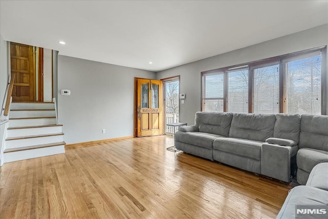 living area featuring stairway, recessed lighting, baseboards, and light wood-type flooring