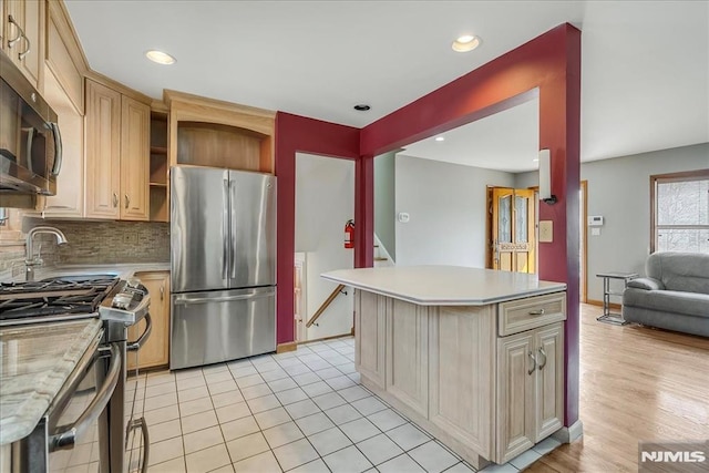 kitchen featuring open shelves, decorative backsplash, light countertops, appliances with stainless steel finishes, and open floor plan