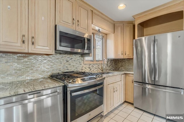 kitchen featuring light tile patterned flooring, light brown cabinets, stainless steel appliances, and a sink