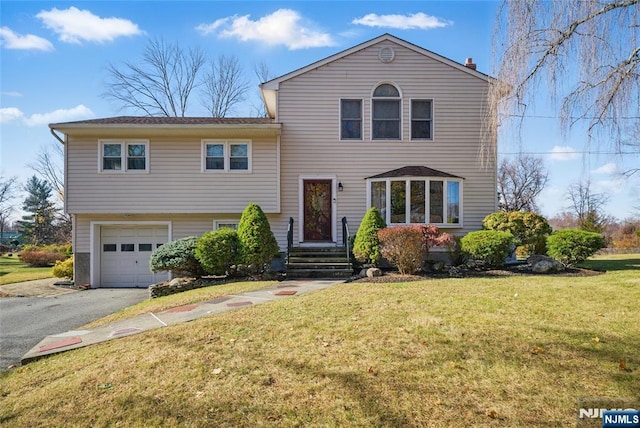 split level home featuring an attached garage, aphalt driveway, and a front lawn