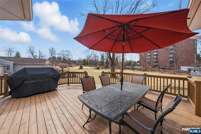 wooden terrace featuring a grill and outdoor dining area