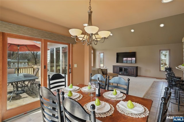 dining area with vaulted ceiling, a healthy amount of sunlight, recessed lighting, and an inviting chandelier