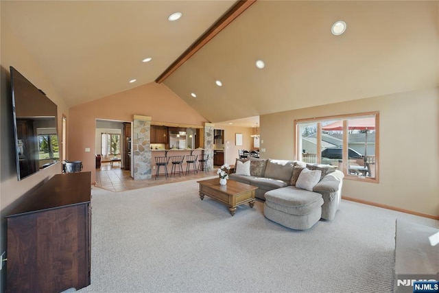 living area with high vaulted ceiling, carpet flooring, and a wealth of natural light