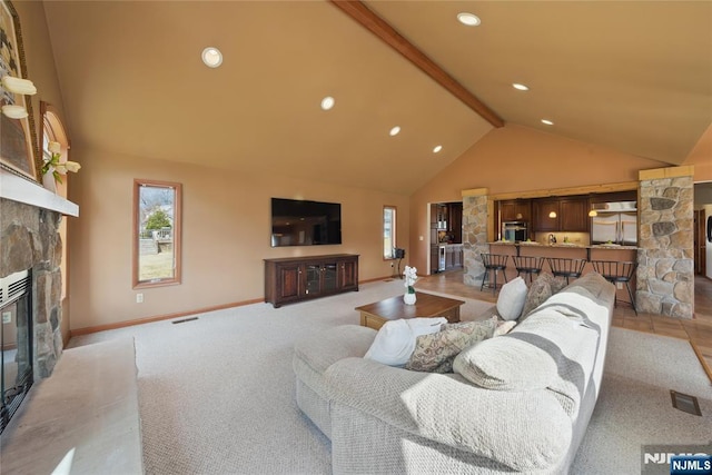 living area featuring beam ceiling, a fireplace, visible vents, light carpet, and high vaulted ceiling