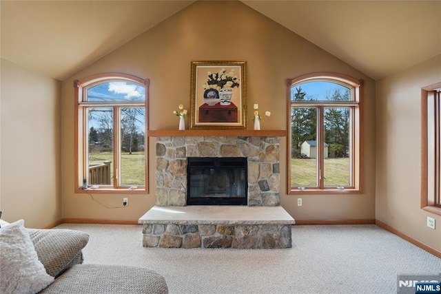 carpeted living room with lofted ceiling, a stone fireplace, plenty of natural light, and baseboards