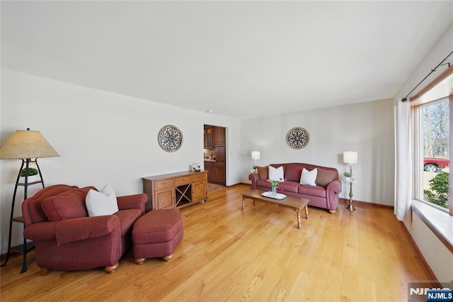 living area featuring light wood-style flooring and baseboards