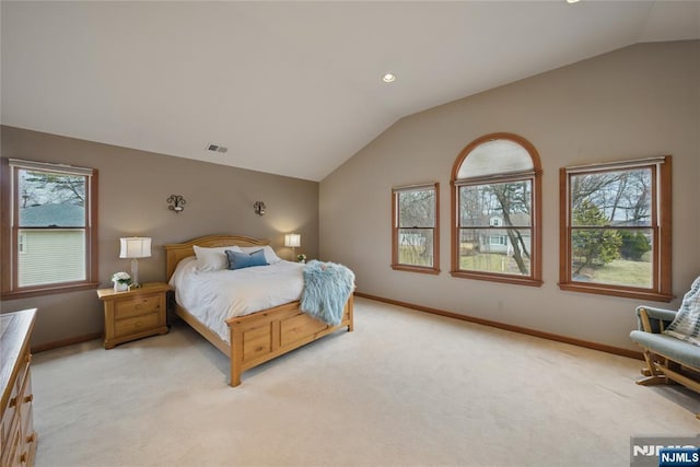 bedroom featuring multiple windows, vaulted ceiling, and light colored carpet