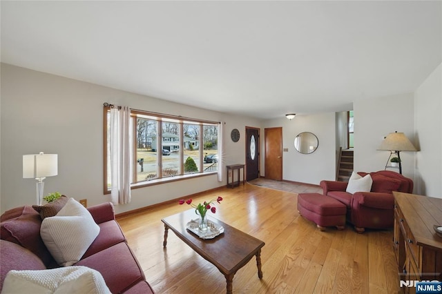 living area with light wood finished floors, stairway, and baseboards