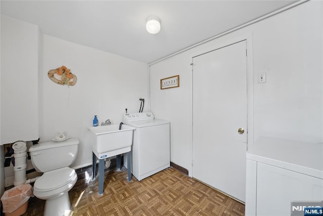 bathroom featuring washer / clothes dryer and toilet