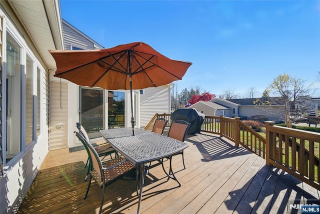 deck with outdoor dining space and grilling area