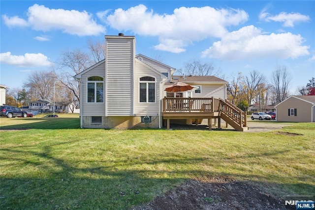 back of property with a lawn, a chimney, a wooden deck, and stairs