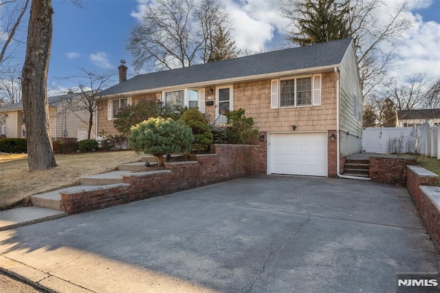 ranch-style house featuring concrete driveway, an attached garage, fence, and a chimney